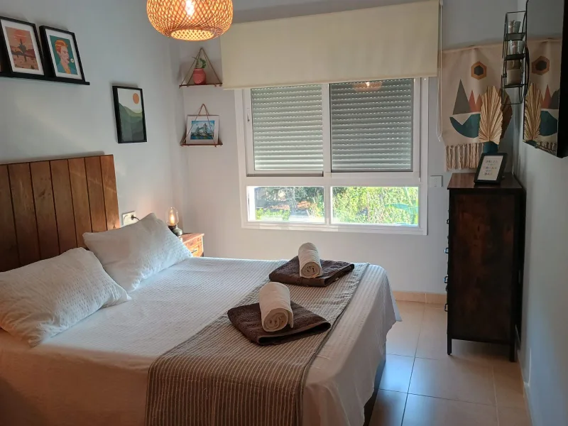 Dormitorio principal con cama doble y cabecero de madera