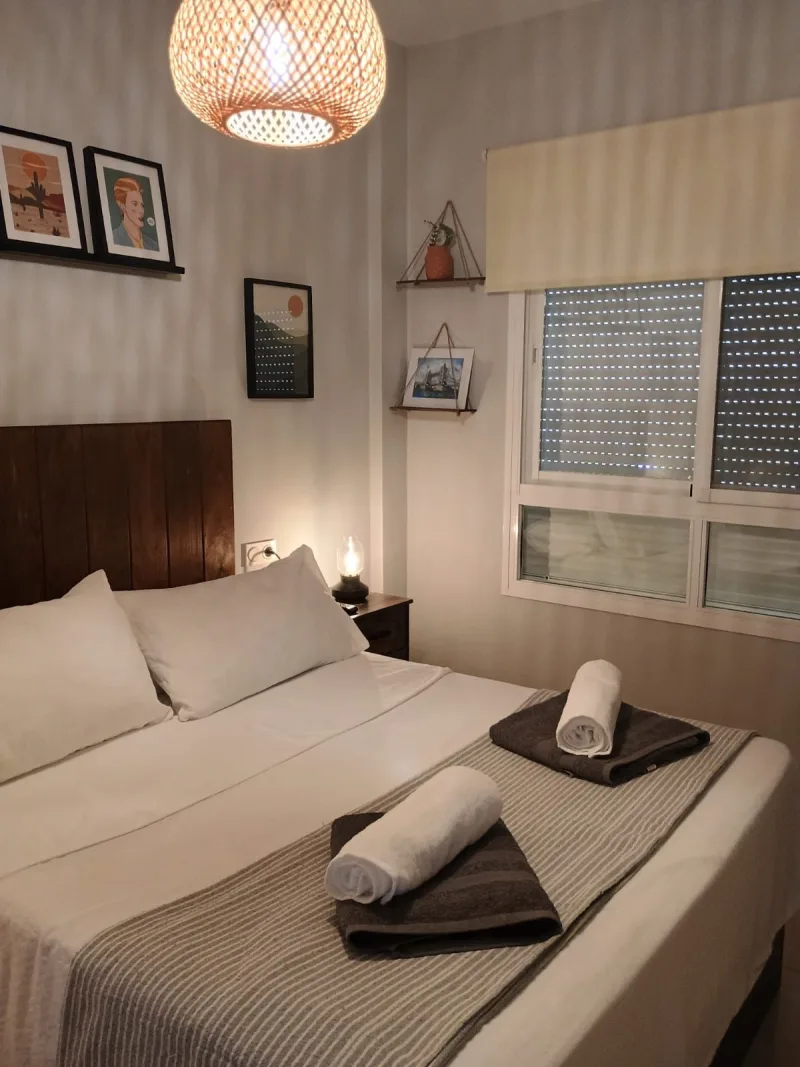 Dormitorio principal de noche, con toallas preparadas